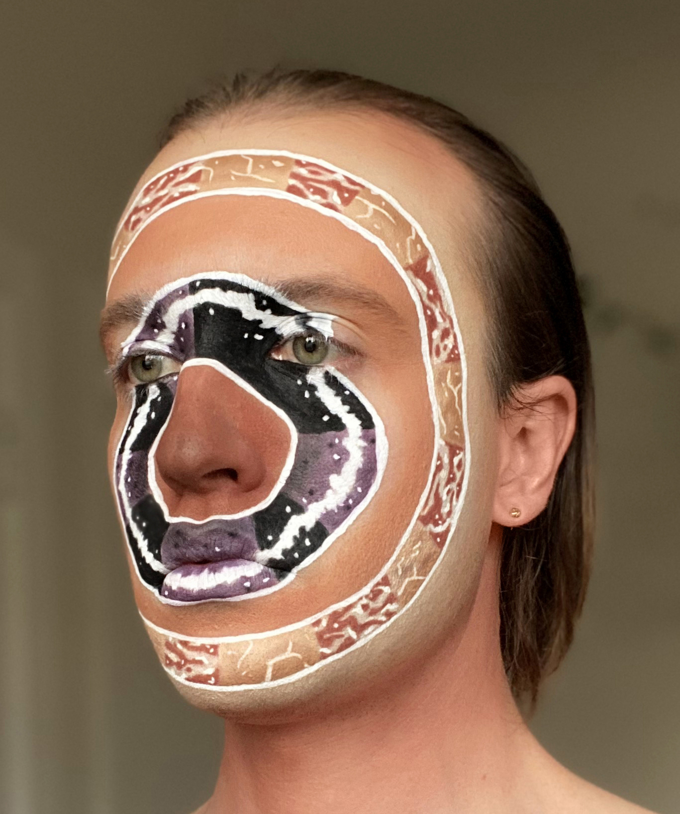 Jesse with intricate graphic facepaint mimicing Isamu Noguchi marble round sculptures